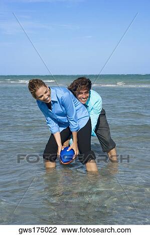 Mid adult couple playing rugby on the beach View Large Photo Image Stock Image - Mid adult couple playing rugby on the beach. Fotosearch