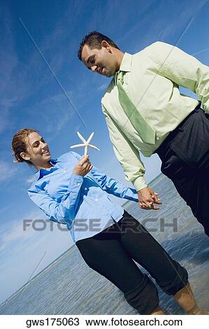 Mid adult couple standing on the beach with a starfish View Large Photo Image Stock Image - Mid adult couple standing on the beach with a starfish. Fotosearch