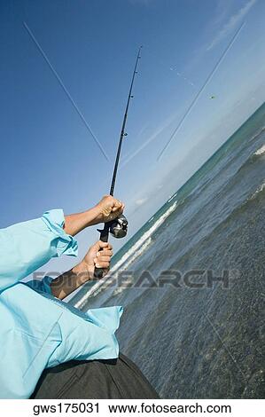 Mid section view of a man fishing in the sea View Large Photo Image Stock Image - Mid section view of a man fishing in the sea. Fotosearch