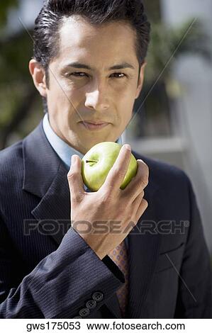 Portrait of a businessman eating a granny smith apple View Large Photo Image Stock Image - Portrait of a businessman eating a granny smith apple. Fotosearch