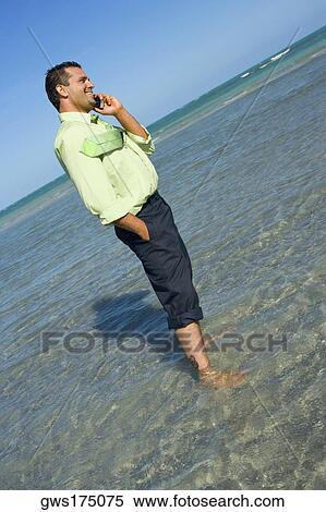 Side profile of a mid adult man talking on a mobile phone on the beach View Large Photo Image Stock Photography - Side profile of a mid adult man talking on a mobile phone on the beach. Fotosearch