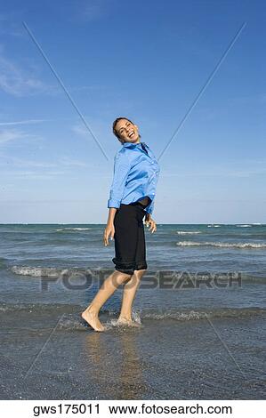 Stock Image - Side profile of a mid adult woman standing on the beach. Fotosearch