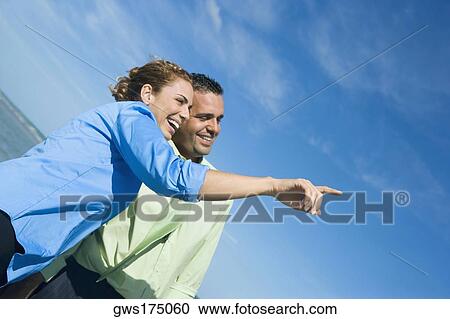 Side profile of a mid adult woman pointing with a mid adult man standing beside her View Large Photo Image Stock Image - Side profile of a mid adult woman pointing with a mid adult man standing beside her. Fotosearch