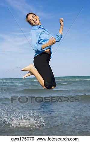 Side profile of a mid adult woman jumping on the beach View Large Photo Image Stock Image - Side profile of a mid adult woman jumping on the beach. Fotosearch
