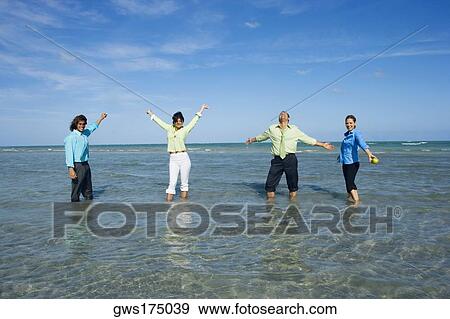 Two mid adult couples standing in water and looking cheerful View Large Photo Image Stock Photo - Two mid adult couples standing in water and looking cheerful. Fotosearch