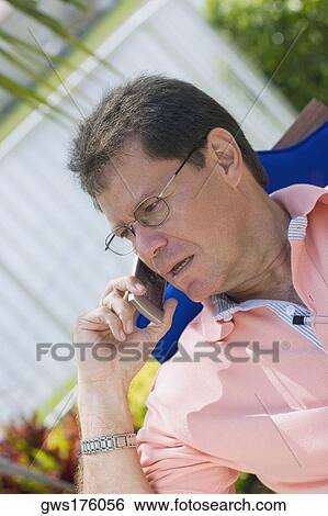 Close-up of a mid adult man talking on a mobile phone View Large Photo Image Stock Photograph - Close-up of a mid adult man talking on a mobile phone. Fotosearch