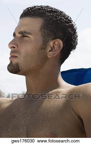 Close-up of a young man looking away View Large Photo Image Stock Image - Close-up of a young man looking away. Fotosearch