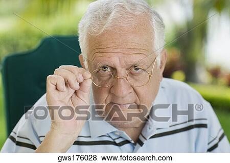 Portrait of a senior man adjusting his eyeglasses View Large Photo Image Stock Photo - Portrait of a senior man adjusting his eyeglasses. Fotosearch