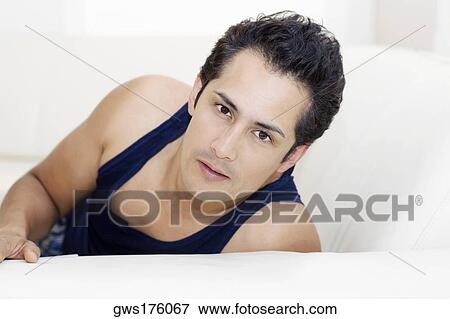 Portrait of a young man reclining on a couch View Large Photo Image Stock Photo - Portrait of a young man reclining on a couch. Fotosearch