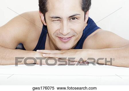Portrait of a young man winking his eyes and smiling View Large Photo Image Stock Photography - Portrait of a young man winking his eyes and smiling. Fotosearch