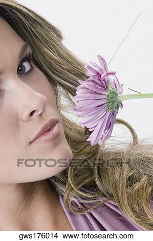 Portrait of a young woman smelling a flower View Large Photo Image Picture - Portrait of a young woman smelling a flower. Fotosearch