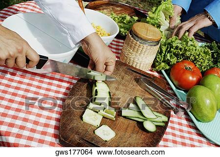 Close-up of a person's hand cutting vegetable with a kitchen knife View Large Photo Image Picture - Close-up of a person's hand cutting vegetable with a kitchen knife. Fotosearch