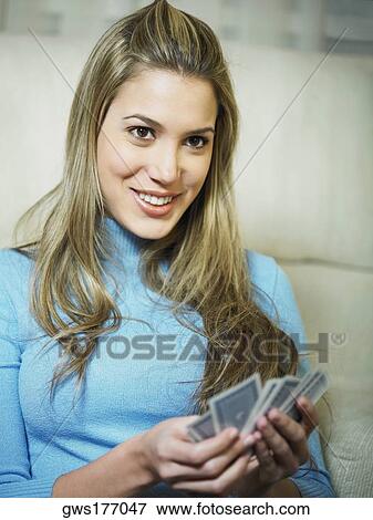 Stock Photo - Close-up of a young woman holding playing cards and smiling. Fotosearch