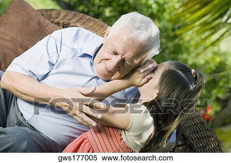 Girl whispering into her grandfather's ear View Large Photo Image Stock Photography - Girl whispering into her grandfather's ear. Fotosearch