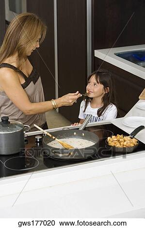 Mature woman feeding her daughter in a kitchen View Large Photo Image Stock Image - Mature woman feeding her daughter in a kitchen. Fotosearch