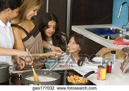 Mature woman standing with her two daughters and a maid smiling in the kitchen View Large Photo Image Stock Image - Mature woman standing with her two daughters and a maid smiling in the kitchen. Fotosearch
