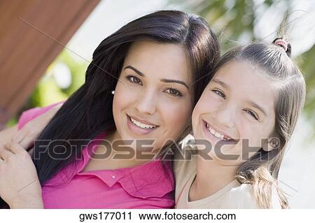 Stock Image - Portrait of a girl with her mother smiling. Fotosearch