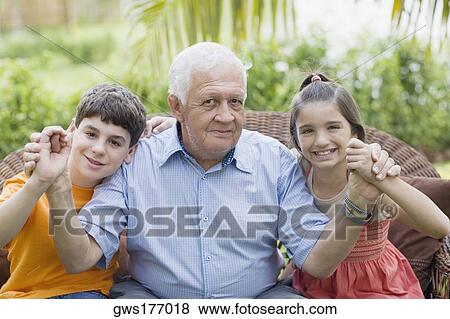 Portrait of a senior man holding his grandchildren's hands and smiling View Large Photo Image Stock Photo - Portrait of a senior man holding his grandchildren's hands and smiling. Fotosearch