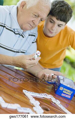 Senior man playing domino with his grandson View Large Photo Image Stock Image - Senior man playing domino with his grandson. Fotosearch