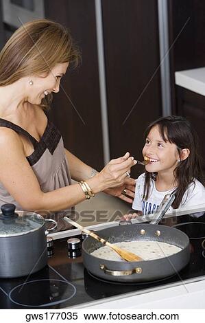 Side profile of a mature woman feeding food to her daughter View Large Photo Image Stock Photography - Side profile of a mature woman feeding food to her daughter. Fotosearch
