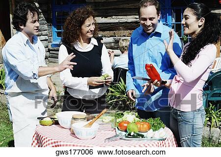 Side profile of a young woman standing with a mature man and a mid adult couple near a table View Large Photo Image Stock Photograph - Side profile of a young woman standing with a mature man and a mid adult couple near a table. Fotosearch