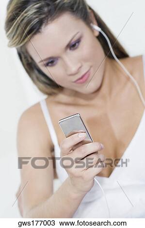 Young woman listening to an MP3 player View Large Photo Image Stock Image - Young woman listening to an MP3 player. Fotosearch