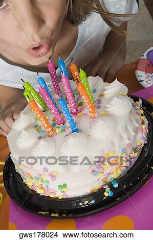 High angle view of a girl blowing candles on her birthday cake View Large Photo Image Picture - High angle view of a girl blowing candles on her birthday cake. Fotosearch