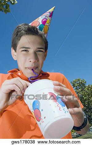 Stock Photo - Low angle view of a boy drinking with a drinking straw. Fotosearch