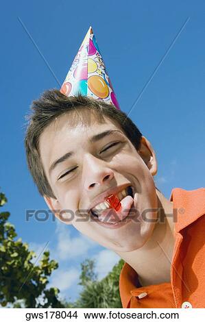 Low angle view of a boy eating a candy View Large Photo Image Picture - Low angle view of a boy eating a candy. Fotosearch