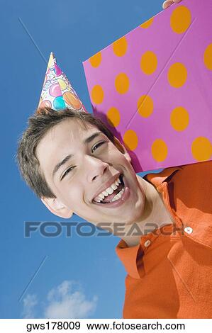Stock Photo - Portrait of a boy holding a birthday present and laughing. Fotosearch