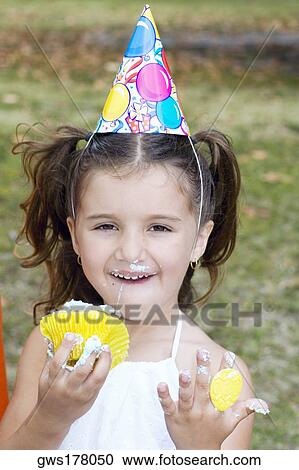 Portrait of a girl eating a cupcake View Large Photo Image Stock Image - Portrait of a girl eating a cupcake. Fotosearch