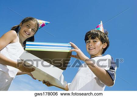 Portrait of a girl giving a birthday present to her brother View Large Photo Image Stock Photograph - Portrait of a girl giving a birthday present to her brother. Fotosearch