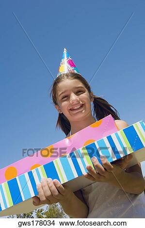 Portrait of a girl holding birthday presents and smiling View Large Photo Image Picture - Portrait of a girl holding birthday presents and smiling. Fotosearch