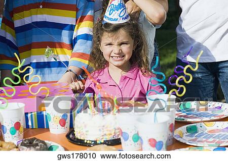 Portrait of a girl standing in front of a birthday cake View Large Photo Image Stock Image - Portrait of a girl standing in front of a birthday cake. Fotosearch