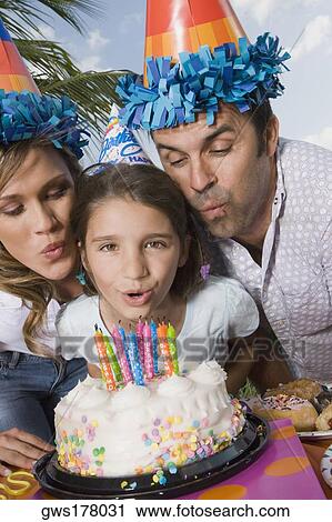 Portrait of a girl with her parents blowing candles on a birthday cake View Large Photo Image Stock Image - Portrait of a girl with her parents blowing candles on a birthday cake. Fotosearch