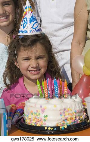 Portrait of a girl with her sisters standing in front of a birthday cake View Large Photo Image Stock Photography - Portrait of a girl with her sisters standing in front of a birthday cake. Fotosearch