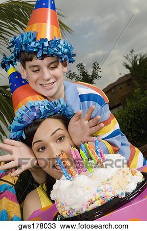 Young woman with her brother in front of a birthday cake View Large Photo Image Stock Image - Young woman with her brother in front of a birthday cake. Fotosearch