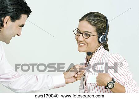 Stock Image - Businessman checking the shirt of a businesswoman. Fotosearch