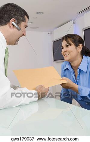 Businessman giving a file to a businesswoman View Large Photo Image Stock Photo - Businessman giving a file to a businesswoman. Fotosearch