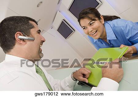 Businesswoman giving a file to a businesswoman and smiling View Large Photo Image Stock Image - Businesswoman giving a file to a businesswoman and smiling. Fotosearch