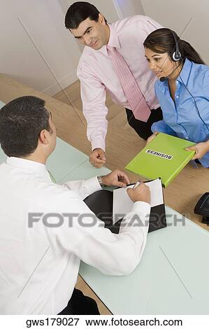 High angle view of two businessmen and a businesswoman talking View Large Photo Image Stock Photo - High angle view of two businessmen and a businesswoman talking. Fotosearch
