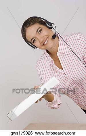 Portrait of a businesswoman holding a package View Large Photo Image Stock Photograph - Portrait of a businesswoman holding a package. Fotosearch