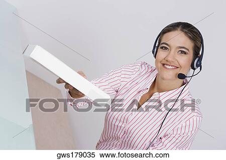 Stock Photography - Portrait of a businesswoman holding a package and smiling. Fotosearch