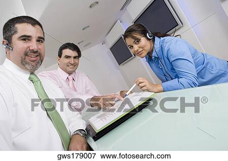 Portrait of two businessmen and a businesswoman smiling View Large Photo Image Stock Photo - Portrait of two businessmen and a businesswoman smiling. Fotosearch