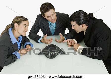 Two businessmen and a businesswoman discussing View Large Photo Image Picture - Two businessmen and a businesswoman discussing. Fotosearch