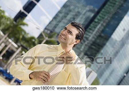 Businessman adjusting his tie View Large Photo Image Stock Image - Businessman adjusting his tie. Fotosearch