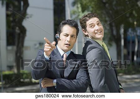 Businessman pointing forward with another businessman standing beside him View Large Photo Image Picture - Businessman pointing forward with another businessman standing beside him. Fotosearch
