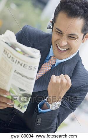 Businessman reading a newspaper and making fists View Large Photo Image Picture - Businessman reading a newspaper and making fists. Fotosearch