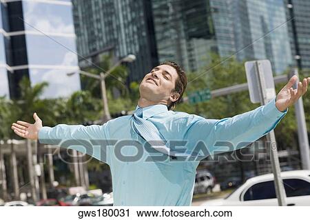 Stock Image - Businessman standing with his arms outstretched. Fotosearch