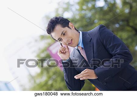 Stock Photo - Businessman talking on a hands free device. Fotosearch